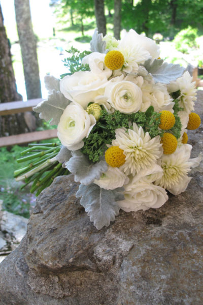 white and yellow bouquet posed on a rock