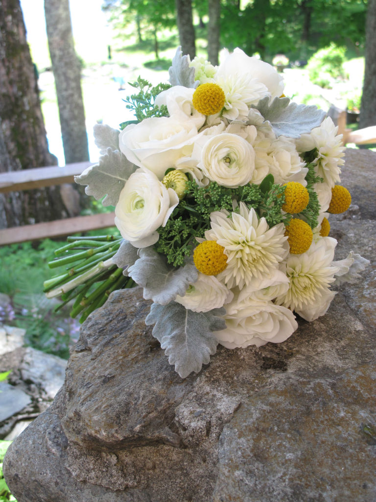white and yellow bouquet posed on a rock