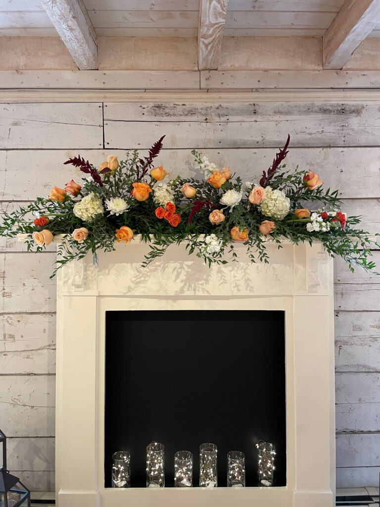 fireplace mantle with flowers displayed on top for a wedding ceremony